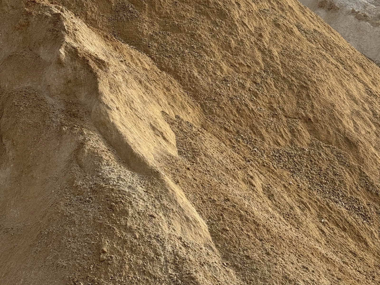 Stockpile of cream-tan crushed limestone fines / ag lime