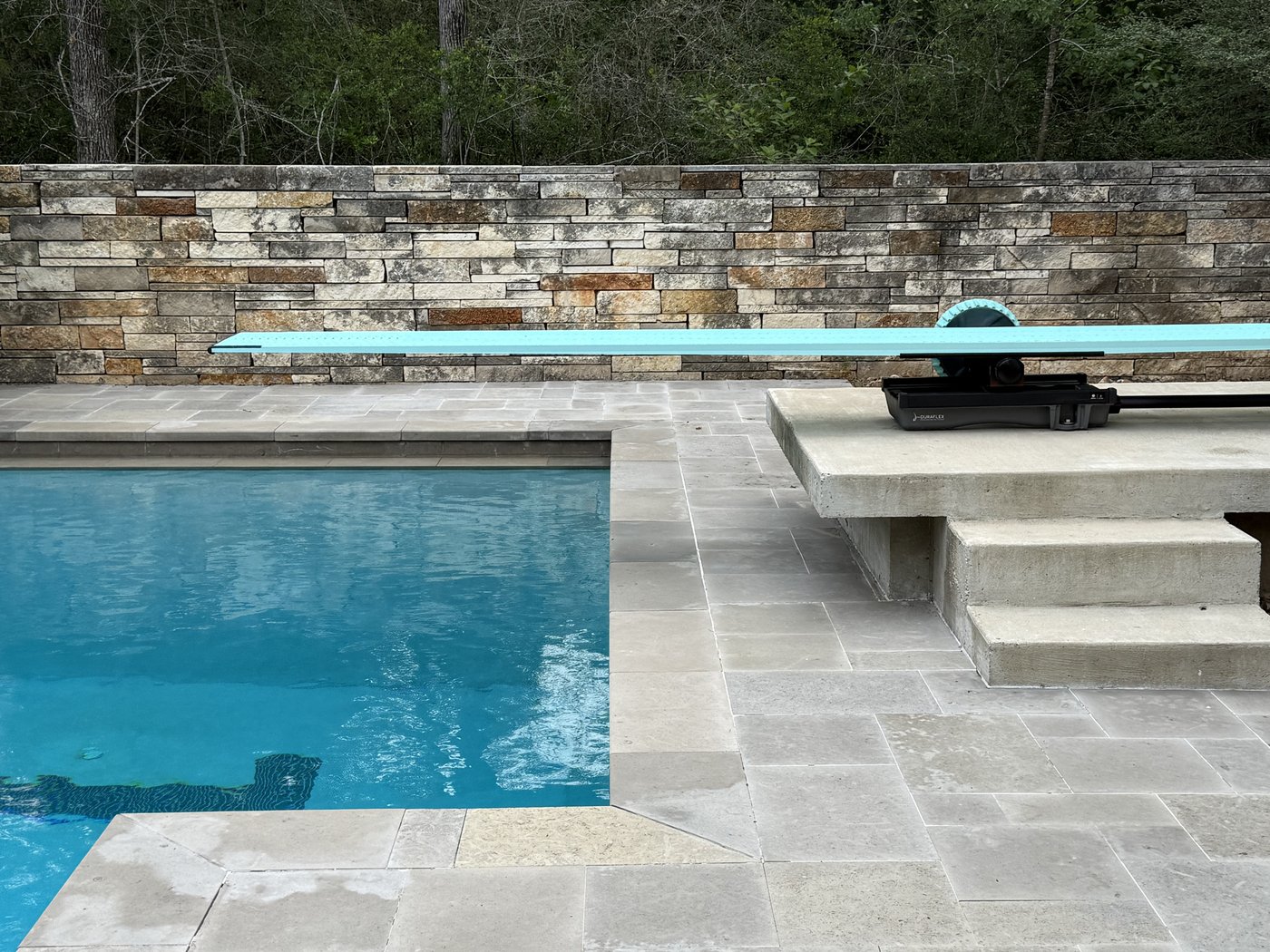 Pool deck with cut limestone coping and a Rusted Earth + Castle Grey 2-4-6 wall behind