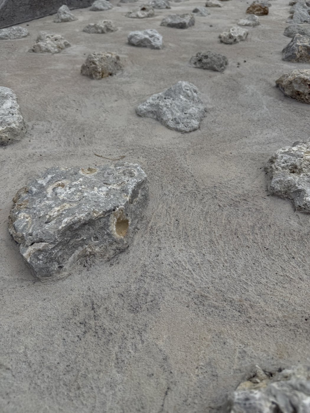 Cemented mixed rubble erosion control — limestone rubble set into a concrete bed for slope stabilization