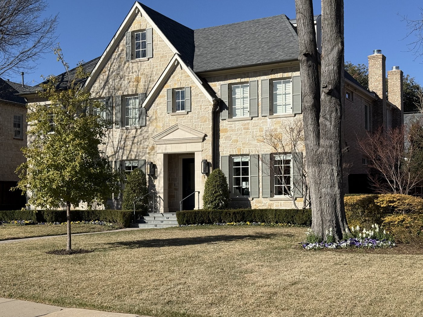 Center-entry residence — Antique limestone in a 4-6-8 ashlar pattern with grey-painted shutters and a small pediment entry