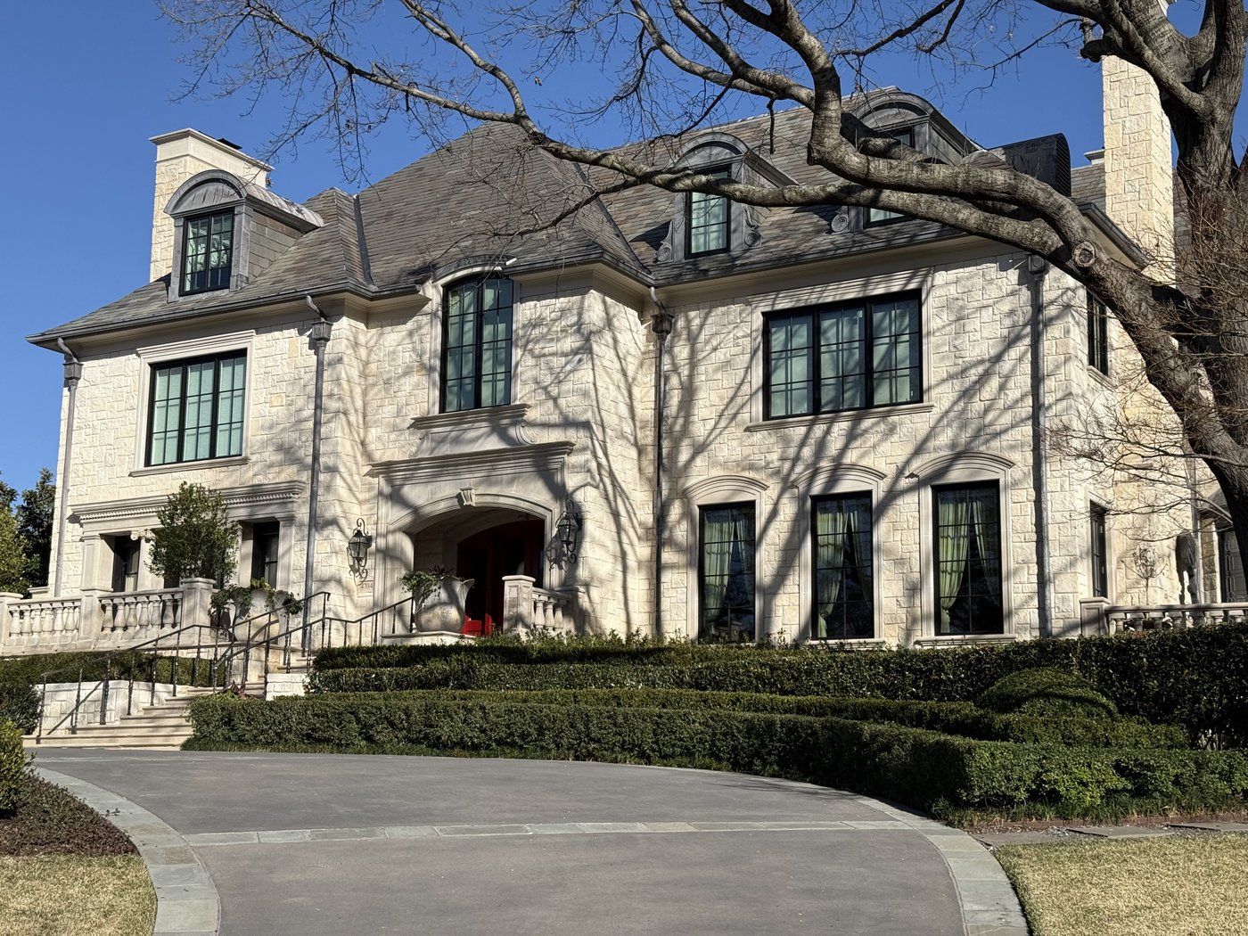 Stately estate residence — Austin White dimensional ashlar across the full front facade with arched windows and dormers