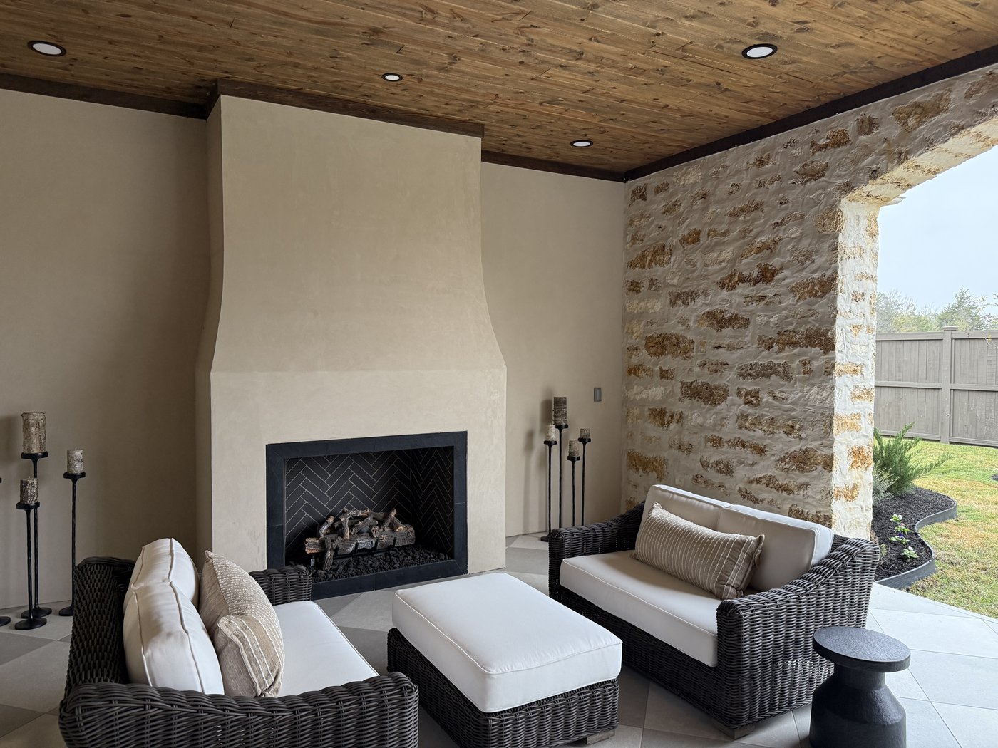 Italian villa side porch — outdoor fireplace and seating area with Cavestone accent wall