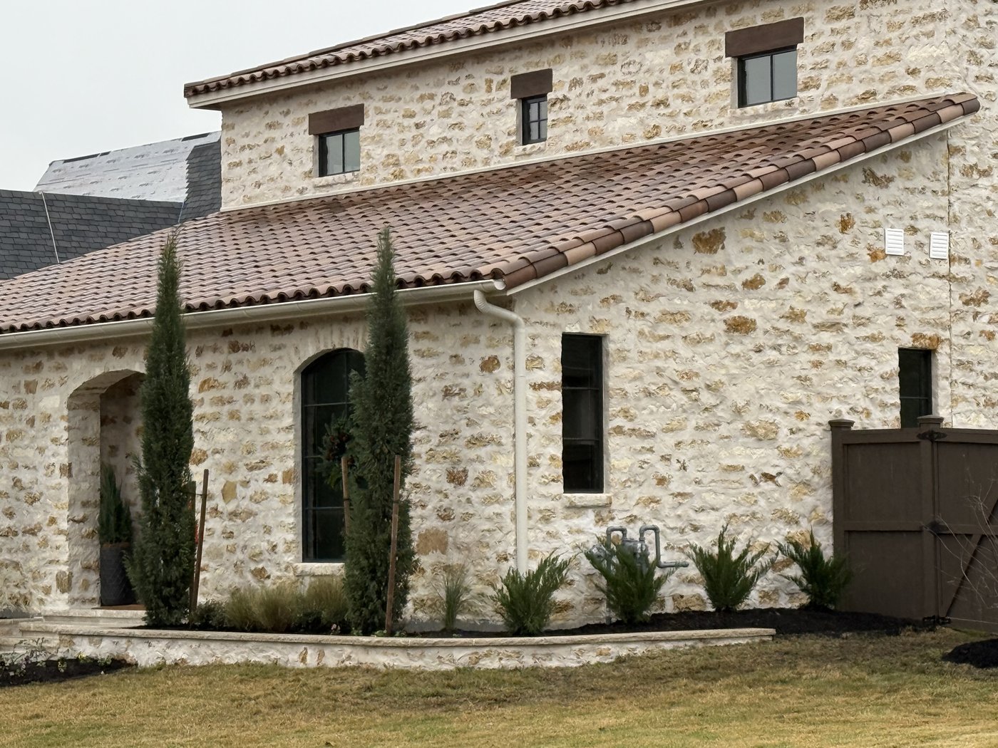 Italian villa — Cavestone random ashlar front facade with arched entry