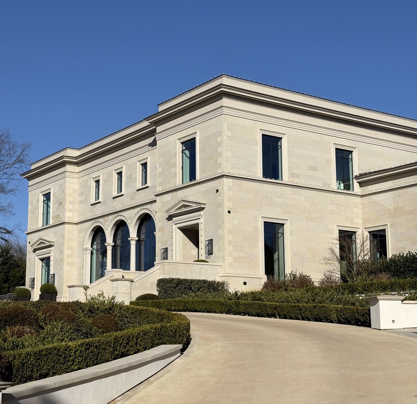 Classical estate — Crescent Cream architectural cut stone facade with triple arched windows and pediment entries