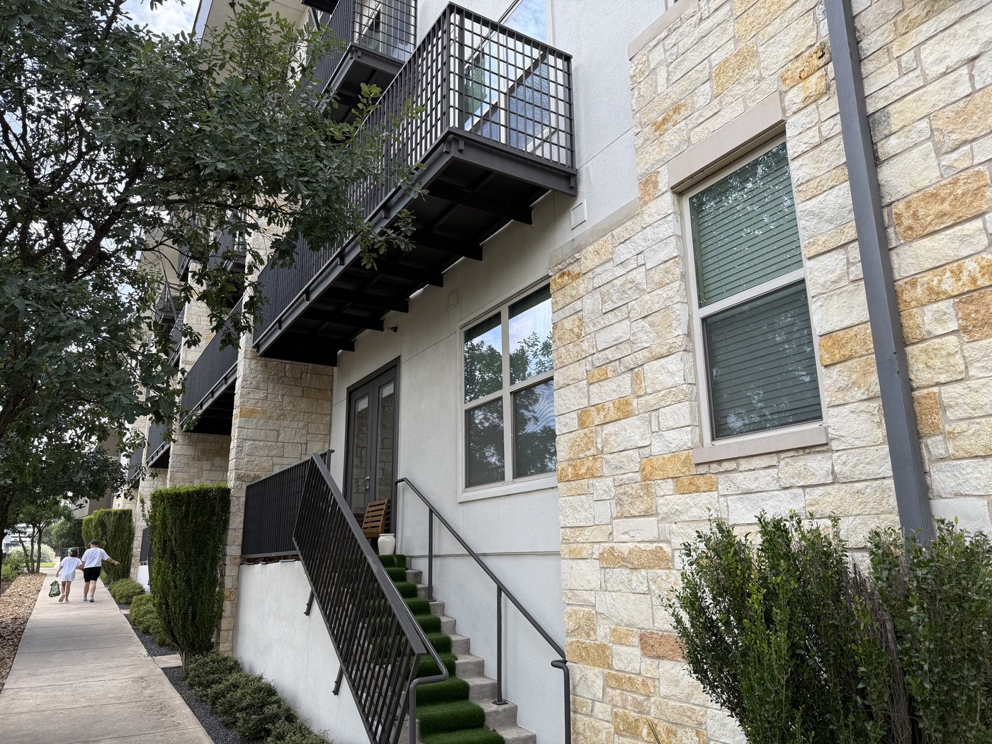 Apartment complex — Goldstone wrapping the ground-floor walls with balconies and entry stairs