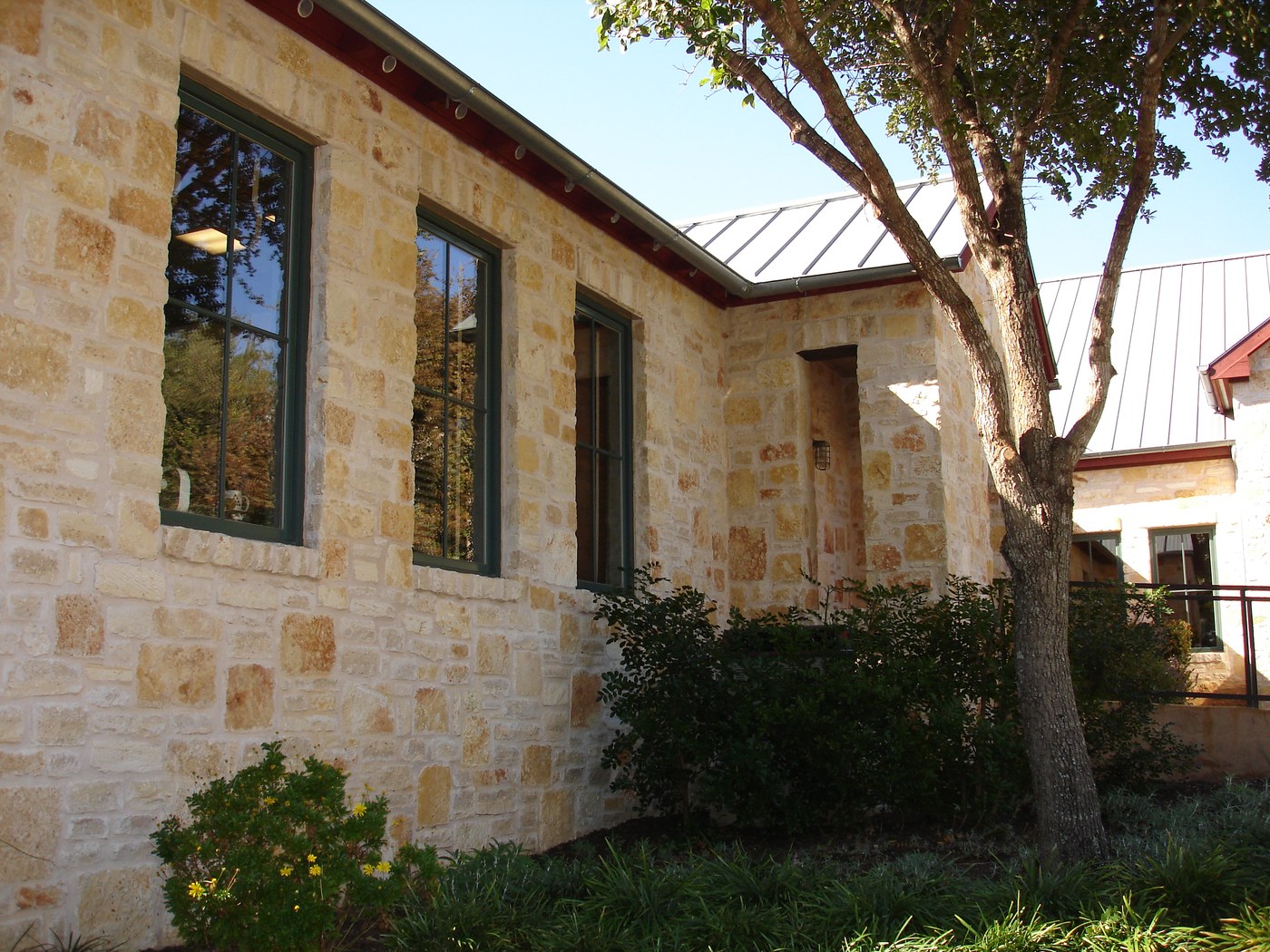Hill Country residence — Rattlesnake Chop random ashlar side elevation under standing-seam metal roof