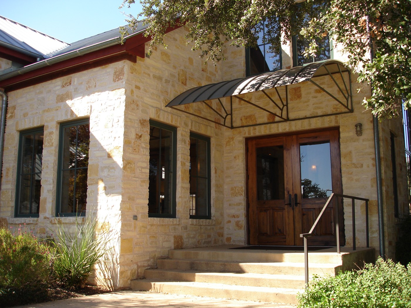 Hill Country residence — Rattlesnake Chop random ashlar front entry with wrought-iron canopy