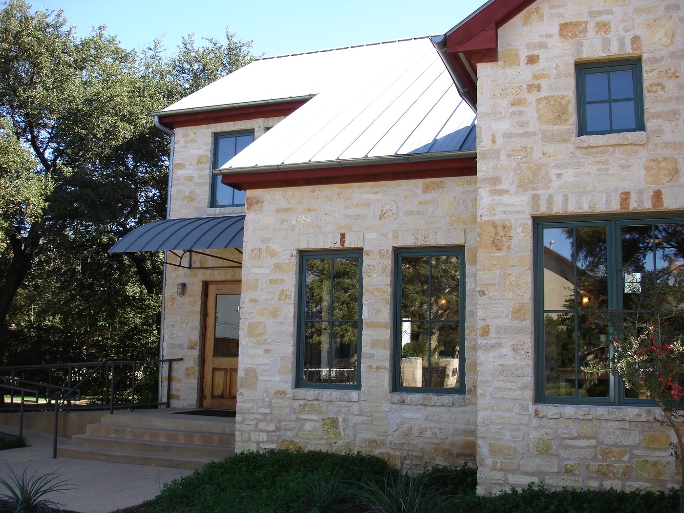 Hill Country residence — Rattlesnake Chop random ashlar two-story side with dormer and metal awning