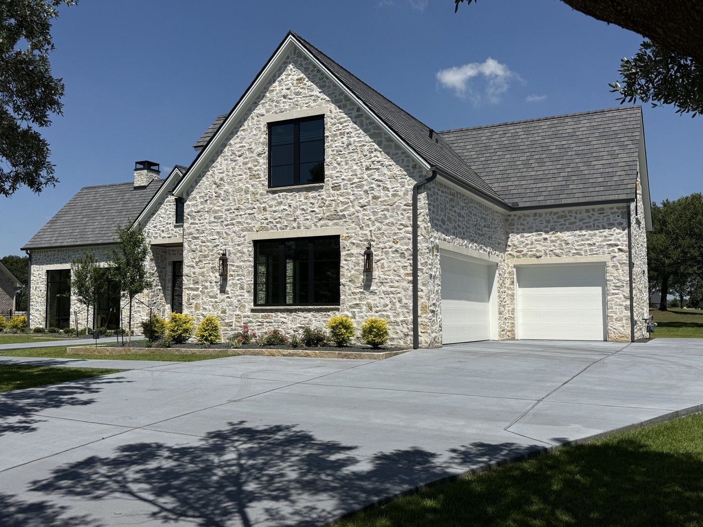 Hill Country estate — Rubble Rock random ashlar with steep gables and a two-car garage