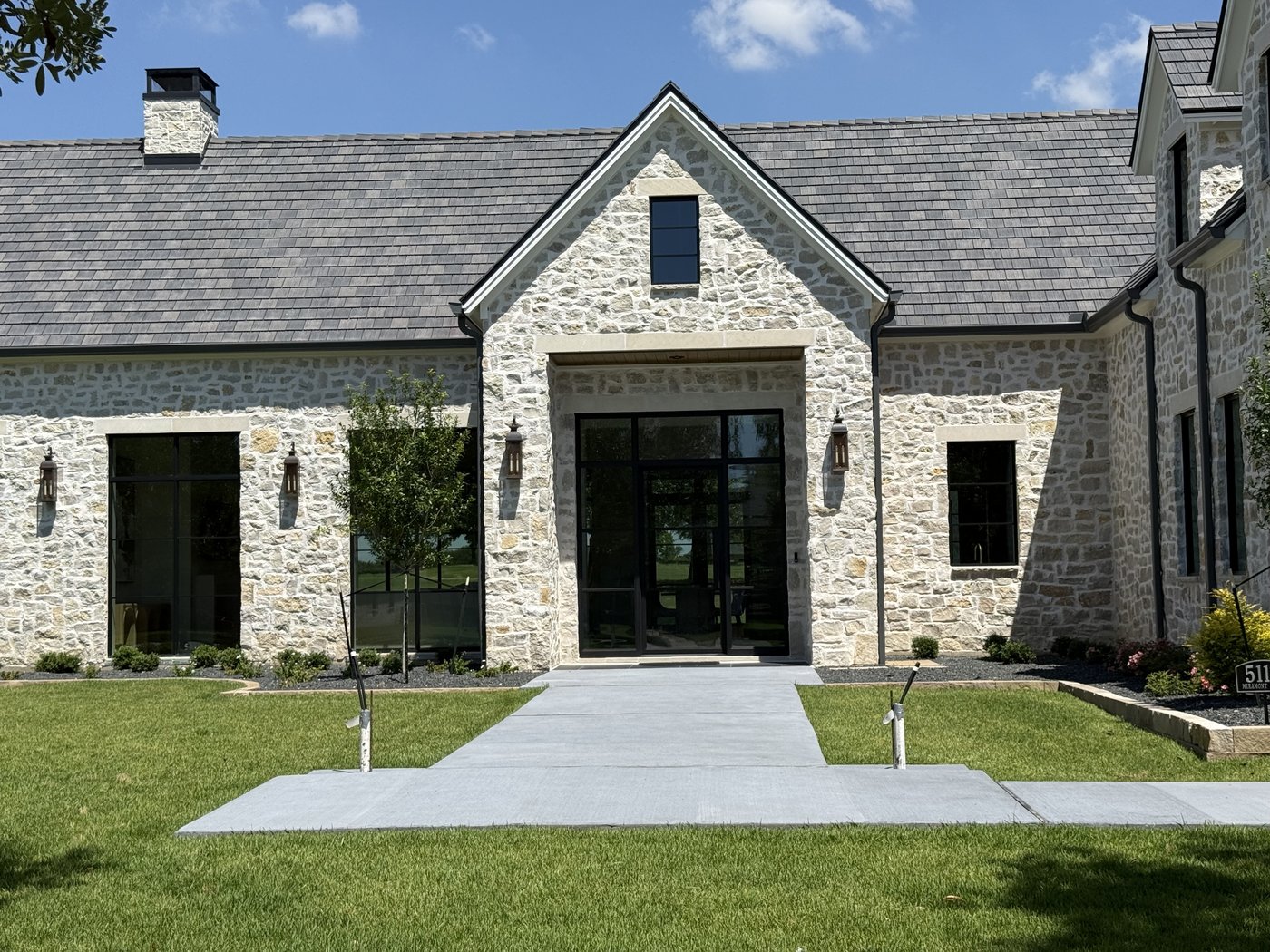 Hill Country estate — Rubble Rock squared front entry with tall glass and slate roof