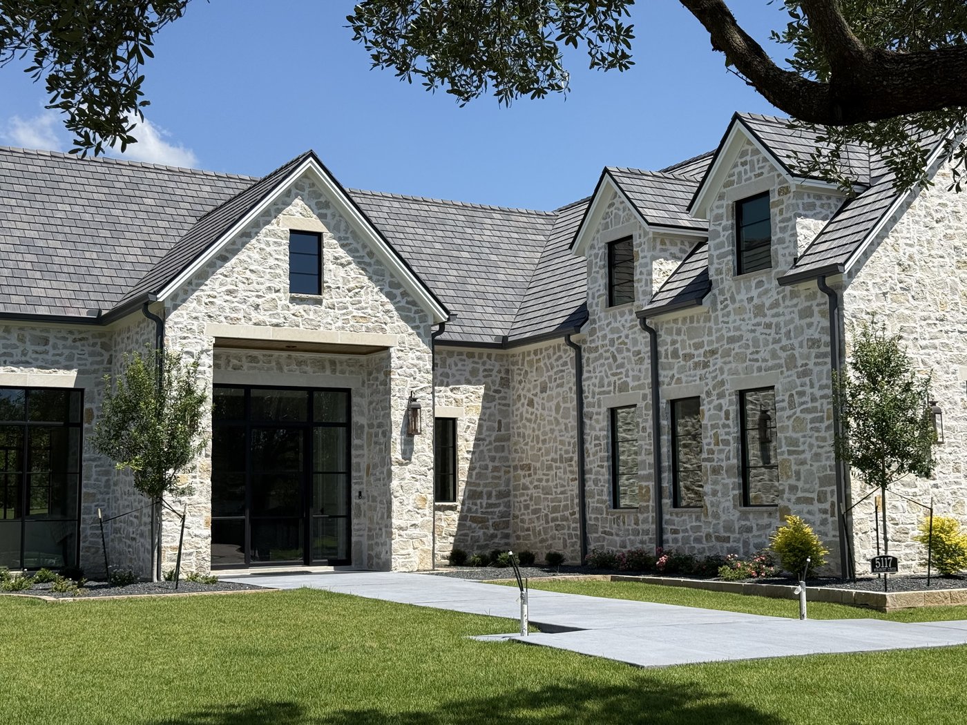 Hill Country estate — Rubble Rock gabled wing with dormer and walkway approach