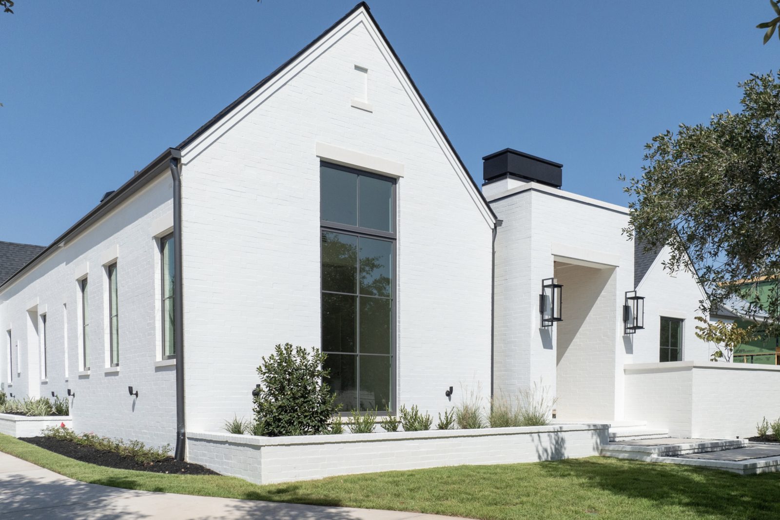 Modern white-brick residence side elevation — tall window with flat white limestone sill and matching flat white limestone header