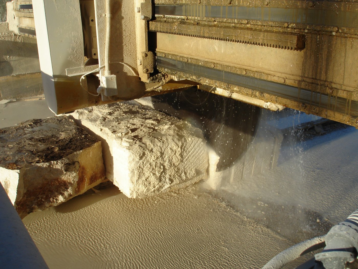 Cooper Stone quarry — diamond-blade saw cutting a limestone block with water spray