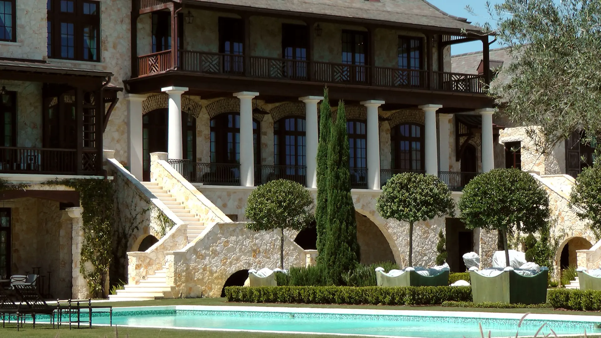 A large house with a pool in front of it