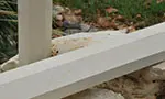 A white bench sitting in the dirt near some rocks.