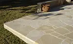 A patio with a cement floor and a planter.