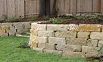 A stone wall in the middle of a garden.